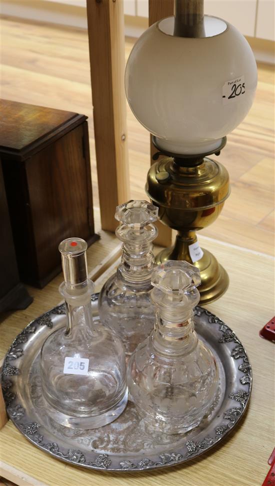 A collection of three cut and moulded decanters and stoppers, together with an oil lamp